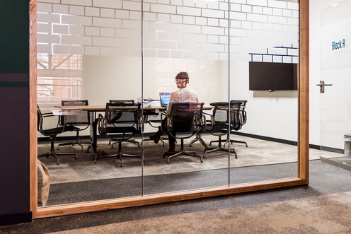 Person arbeitet alleine in Meetingraum Person arbeitet alleine in Meetingraum