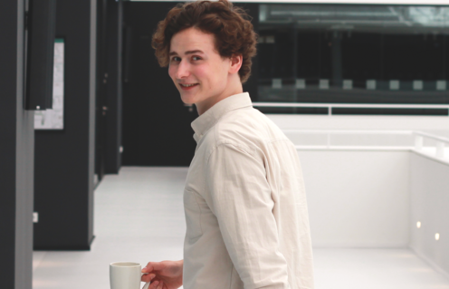 Timon mit Laptop im Büro auf dem Weg zu einem Meeting