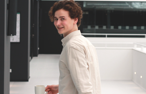 Timon mit Laptop im Büro auf dem Weg zu einem Meeting