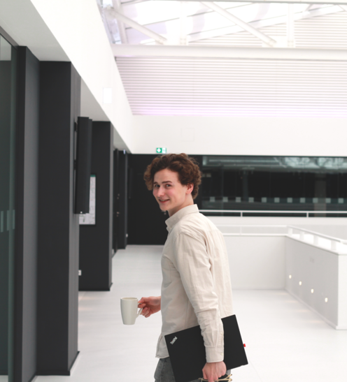 Timon mit Laptop im Büro auf dem Weg zu einem Meeting Timon mit Laptop im Büro auf dem Weg zu einem Meeting